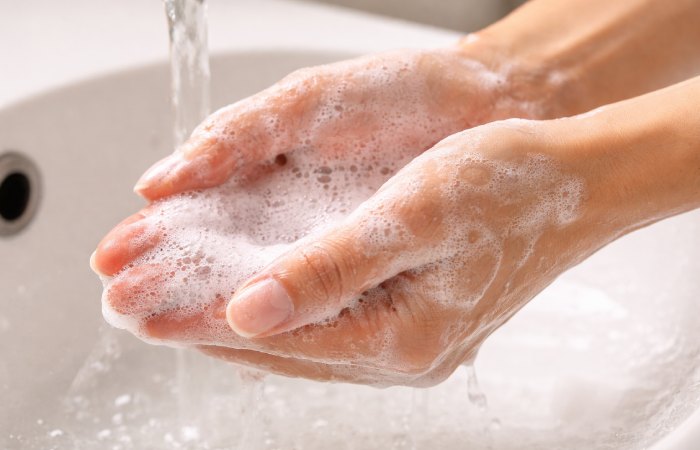 Foaming face cleanser being rinsed from hands