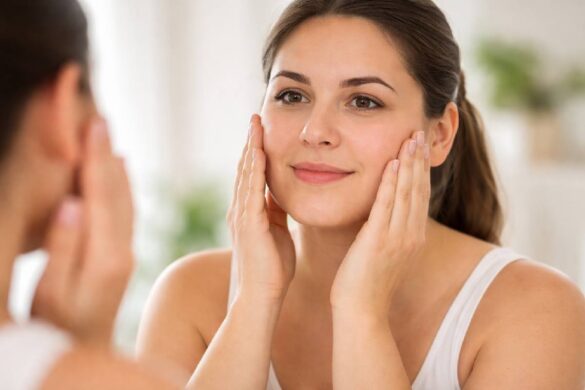 person touching cheeks while looking in mirror